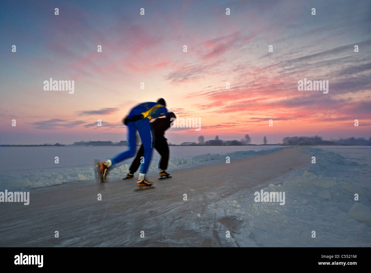 Les Pays-Bas, Gaastmeer, patinage sur lac gelé dans le givre et la neige, au coucher du soleil. Banque D'Images