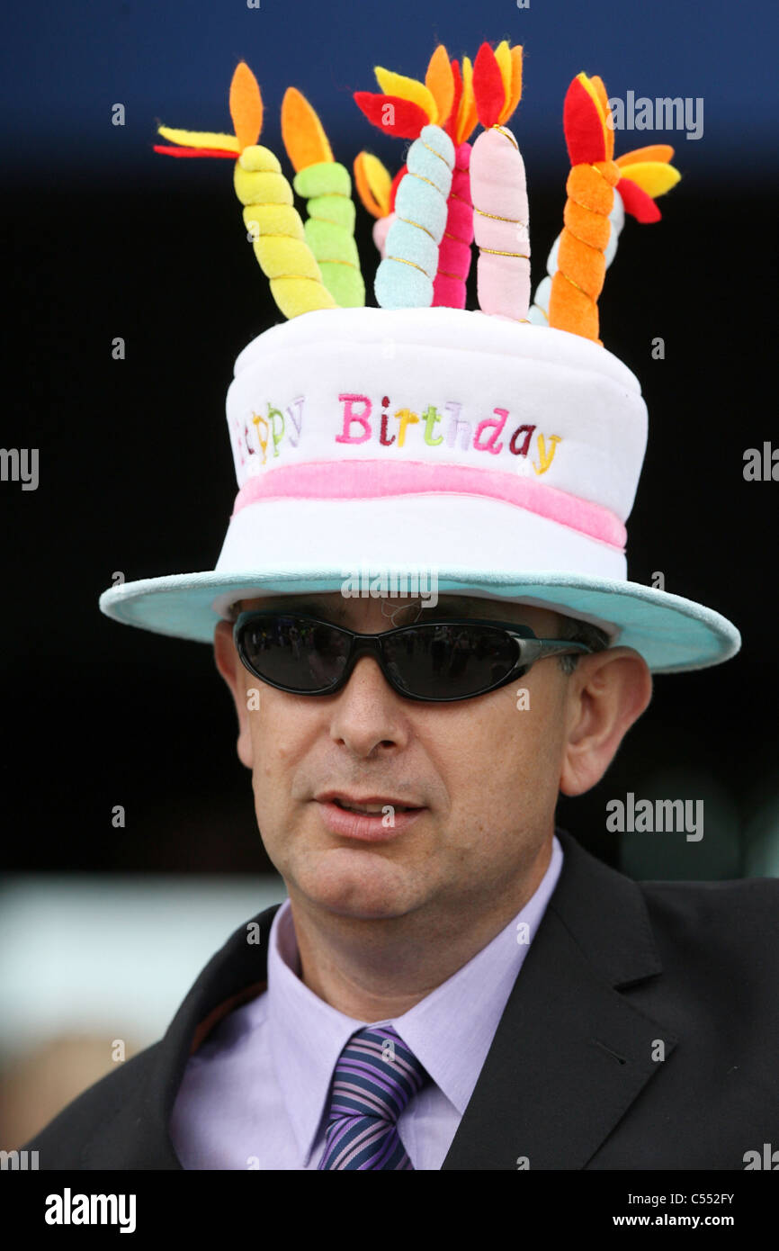 Homme Portant Un Chapeau Qui Ressemble A Un Gateau D Anniversaire L Ascot Royaume Uni Photo Stock Alamy