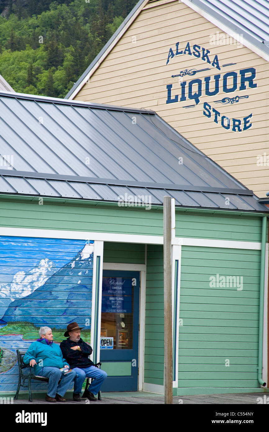 Les gens assis devant un magasin d'alcool, de l'Alaska Liquor Store, 2e  Avenue, Skagway, Alaska, USA Photo Stock - Alamy