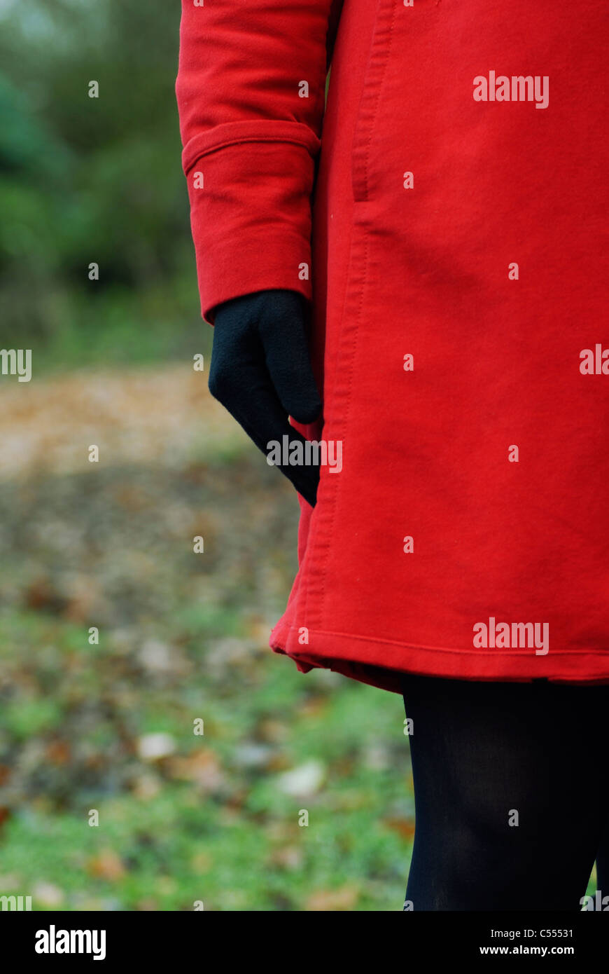 Femme en robe rouge et des gants de standing outdoors Banque D'Images