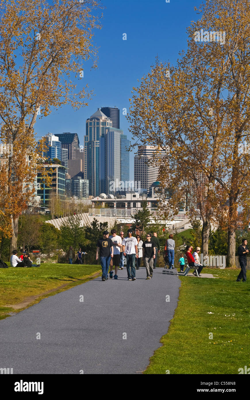 Les gens qui marchent sur le sentier à Myrtle Edwards Park avec Seattle Skyline en arrière-plan Banque D'Images