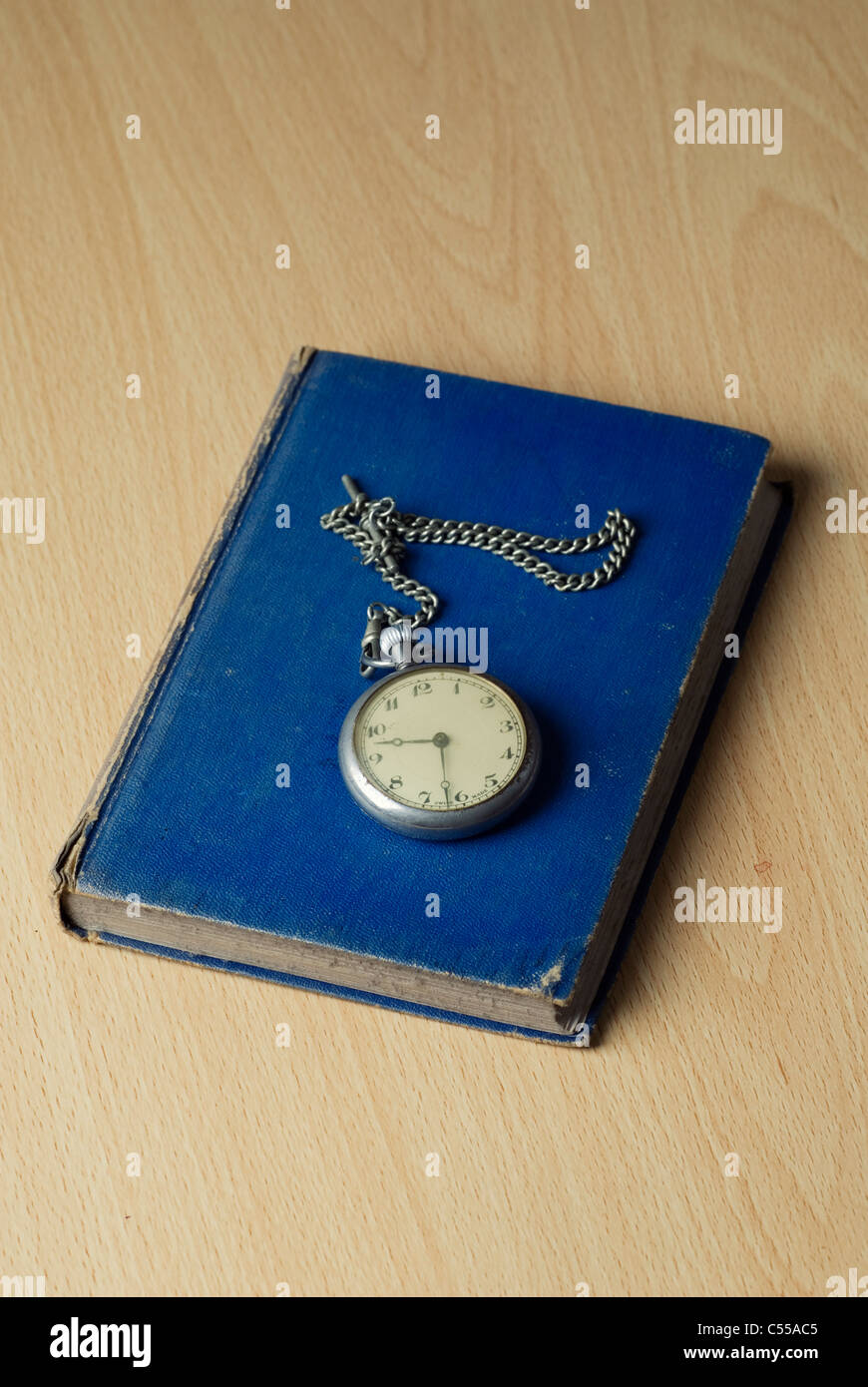 Montre de poche antique au-dessus d'un livre bleu Banque D'Images