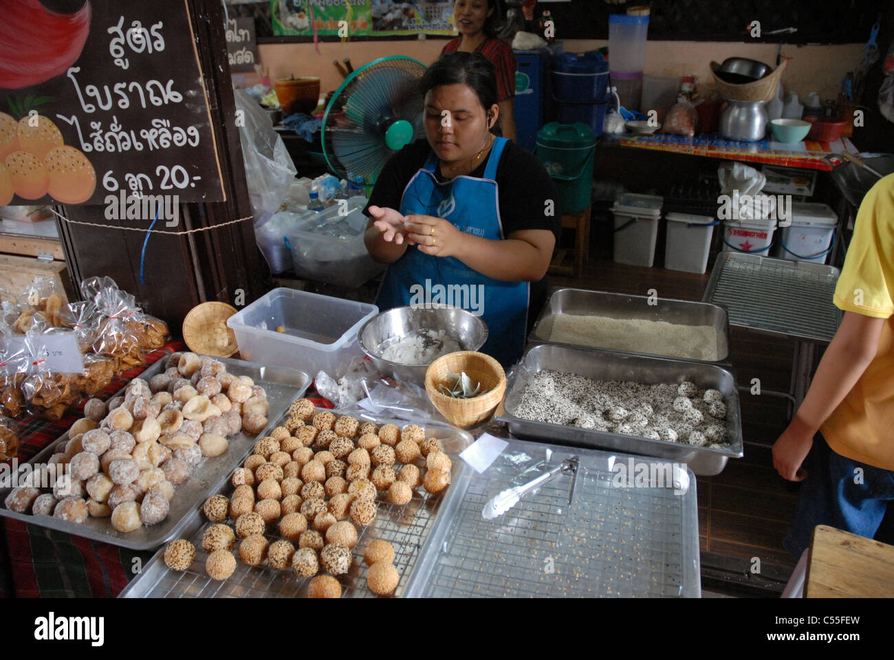 Un vendeur de rue préparant et emballant des encas thaïlandais traditionnels (Jian Dui) à un étal de marché animé, Bangkok, Thaïlande. Banque D'Images