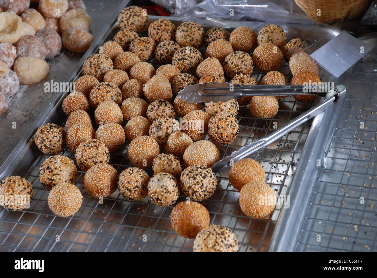 Un plateau de Jian Dui (boules de sésame), une pâtisserie frite traditionnelle chinoise faite à partir de farine de riz gluant et enrobée de graines de sésame, Bangkok, Thaïlande. Banque D'Images