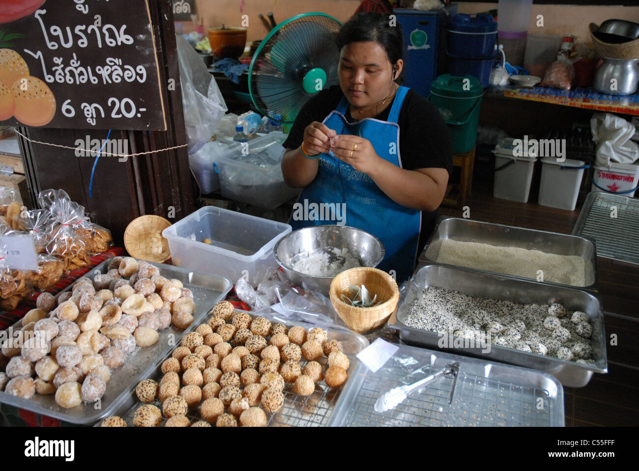 Un vendeur de rue préparant et emballant des encas thaïlandais traditionnels (Jian Dui) à un étal de marché animé, Bangkok, Thaïlande. Banque D'Images