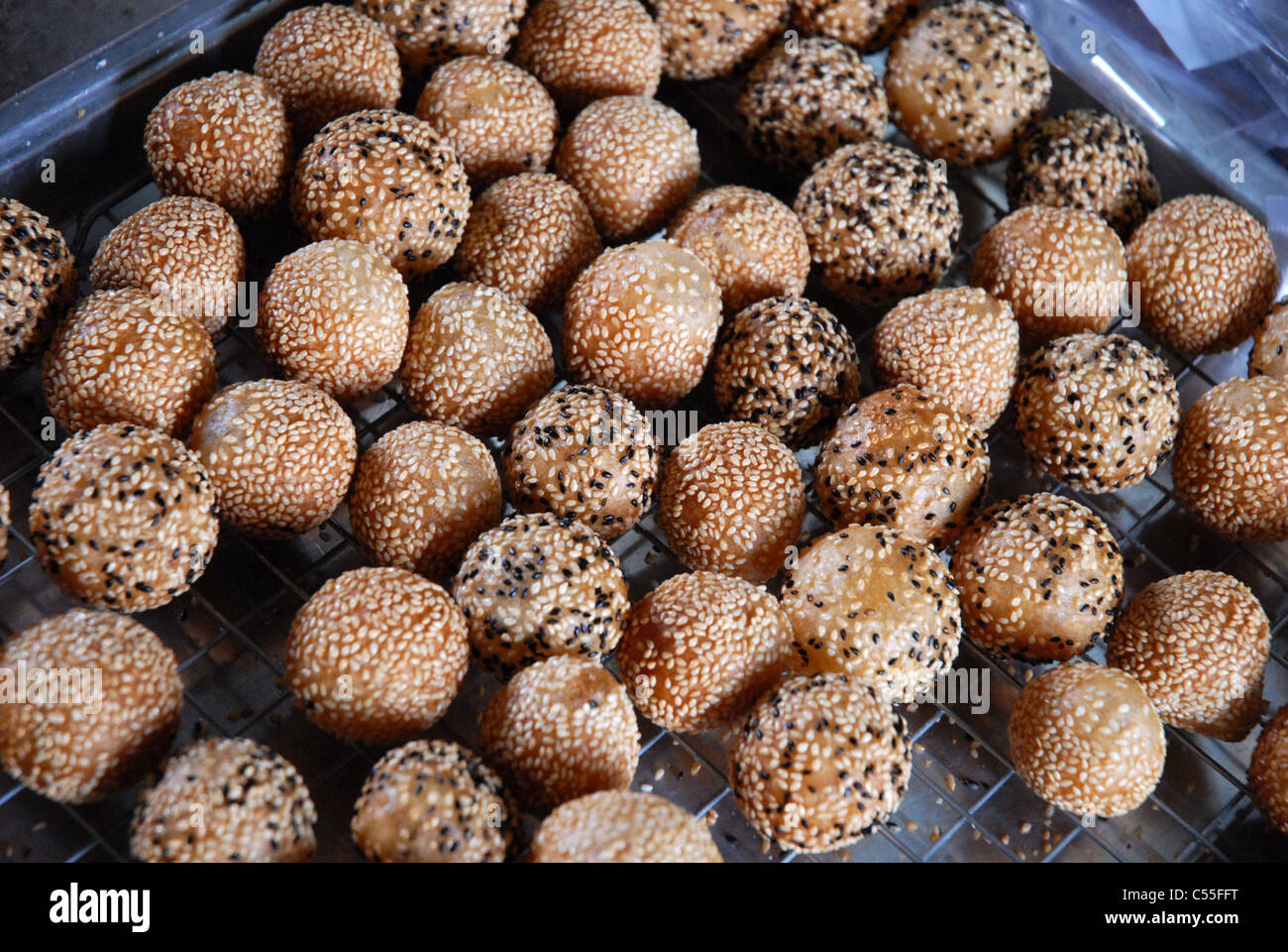 Un plateau de Jian Dui (boules de sésame), une pâtisserie frite traditionnelle chinoise faite à partir de farine de riz gluant et enrobée de graines de sésame, Bangkok, Thaïlande. Banque D'Images