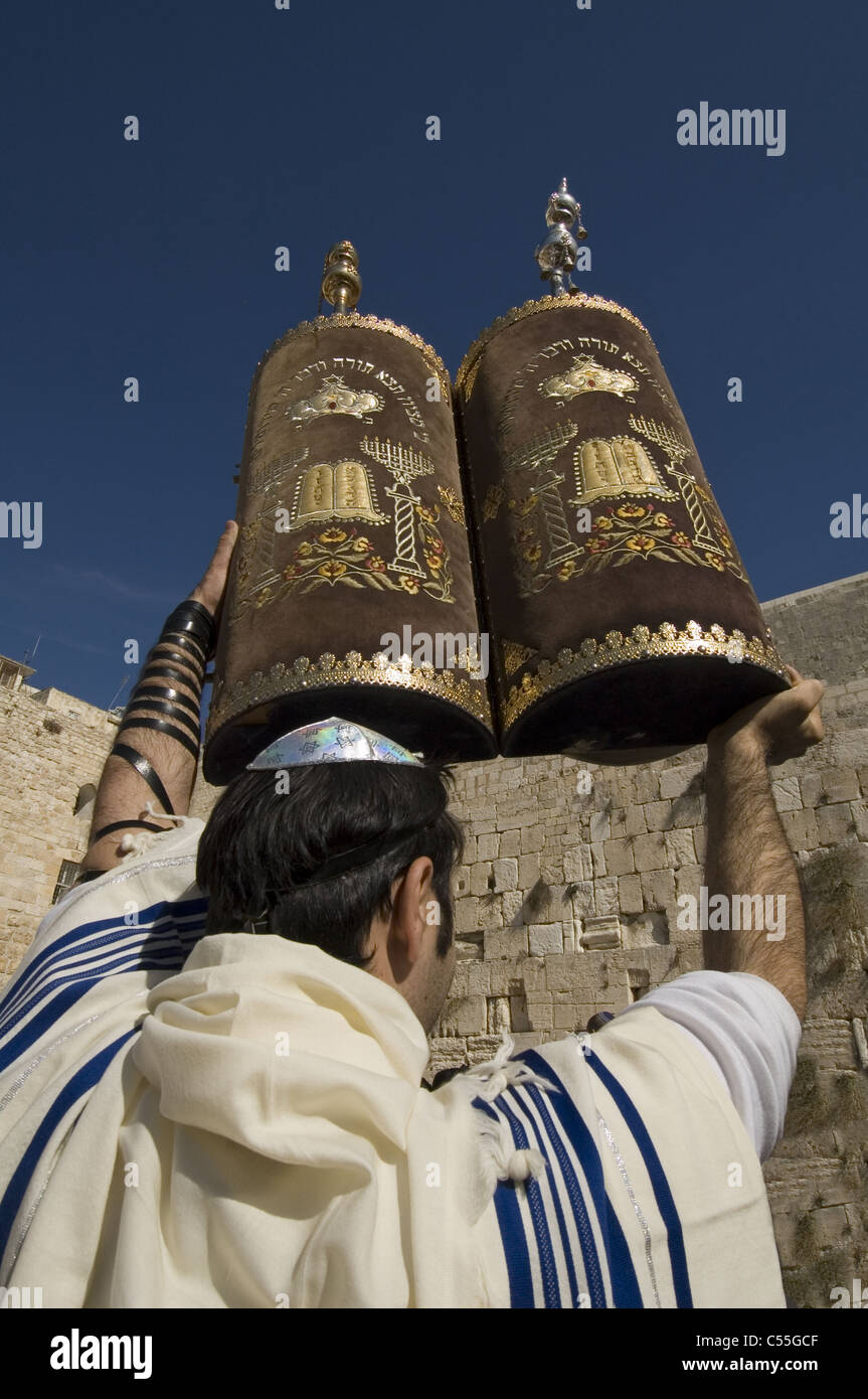 Juif orthodoxe enveloppé de Talit (châle de prière ) maintenant Torah manuscrits sacrés au Mur Occidental à Jérusalem Israël Banque D'Images