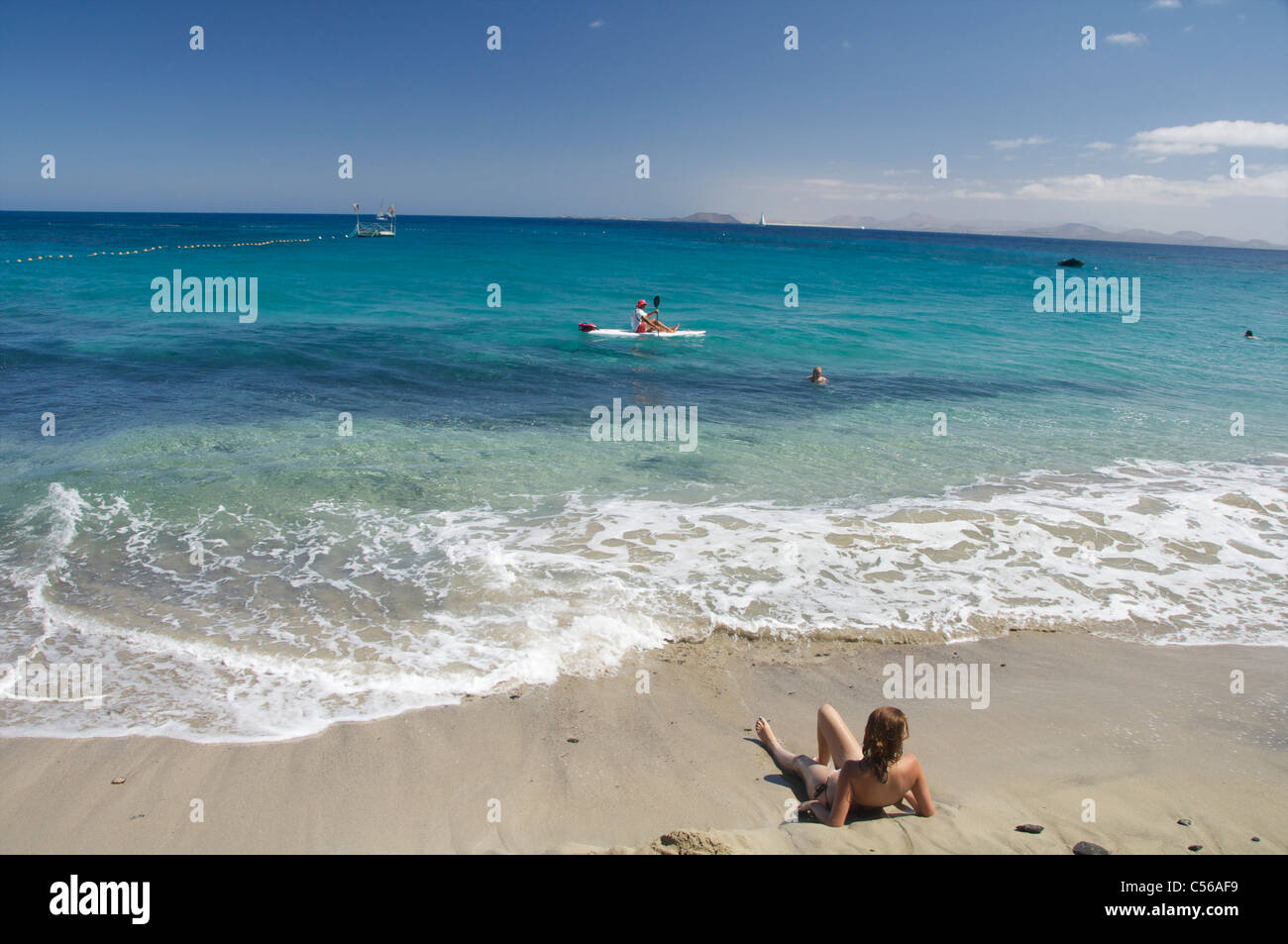 Une fille sur la plage à Playa Blanca, Lanzarote, îles Canaries, Espagne. Banque D'Images