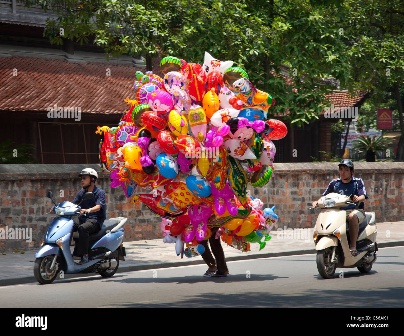 Ballons colorés en cours le long d'une route très fréquentée, Vietnam Banque D'Images