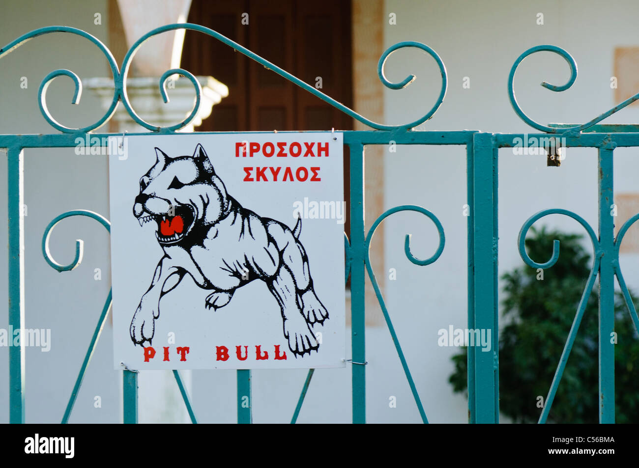 Méfiez-vous de la pit bull dog sign en anglais et grec Banque D'Images