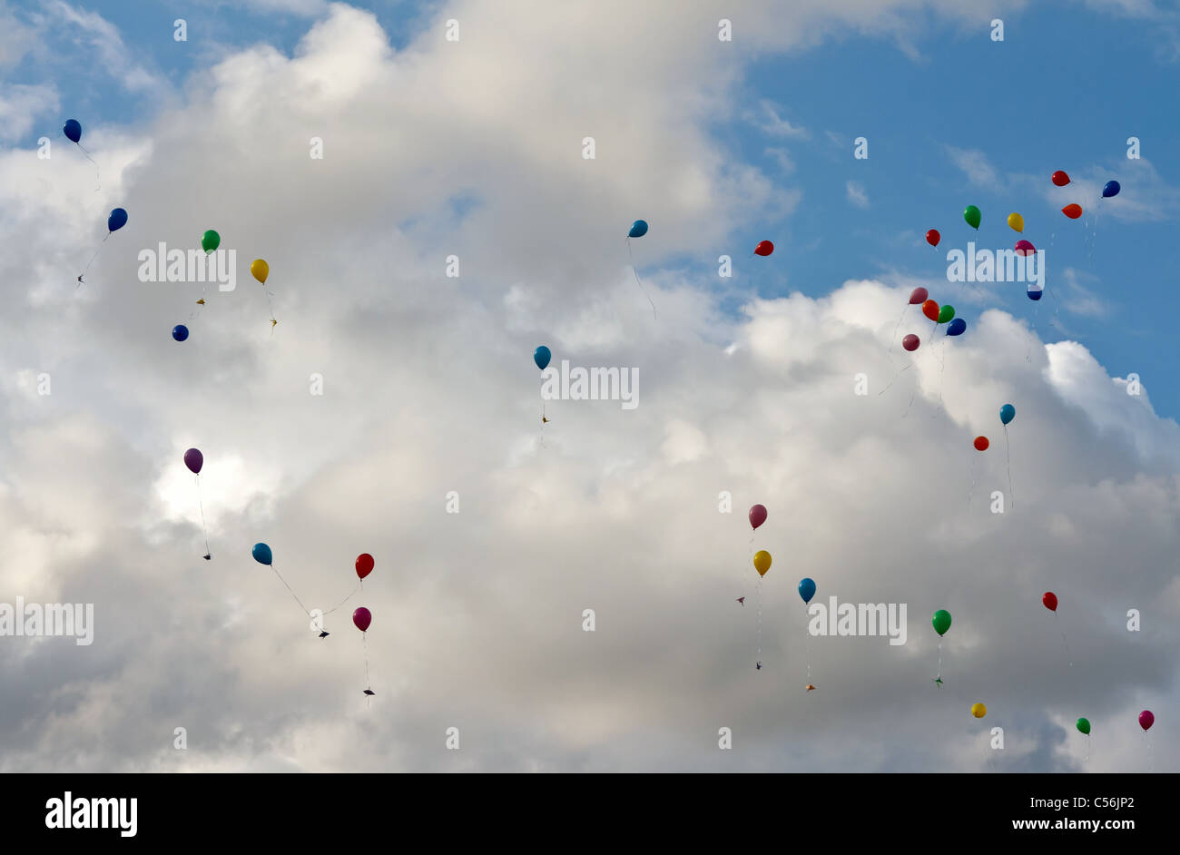Ballons colorés volant dans le ciel avec des nuages Banque D'Images