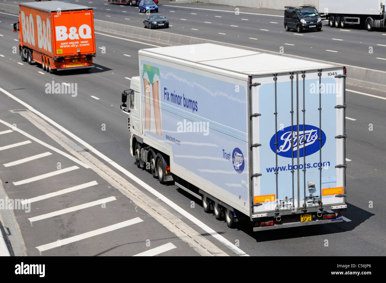 Boots pharmacy business supply chain & poids lourds camion avec remorque camion de distribution à la suite de B&Q magasin de bricolage les véhicules de livraison en voiture sur l'autoroute britannique Banque D'Images