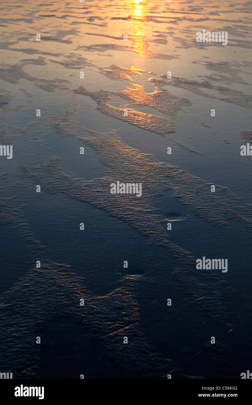 Les Pays-Bas, Marken, lac gelé appelé IJsselmeer. Le coucher du soleil. Banque D'Images