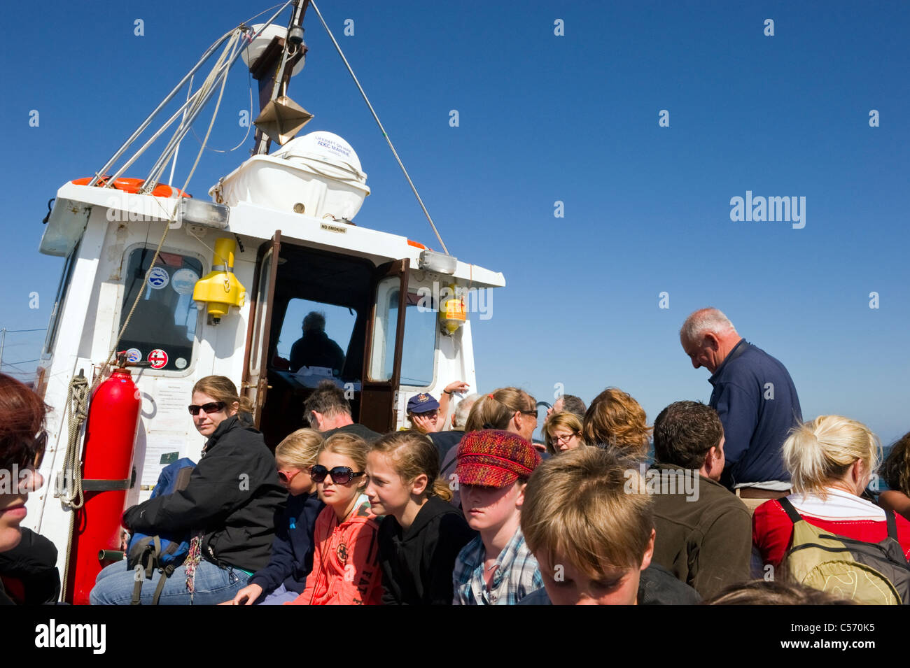 Les passagers et les gens assis dans le bateau naviguant de Dale Princess Martins Haven de Skomer Island South Pembrokeshire Wales UK Banque D'Images