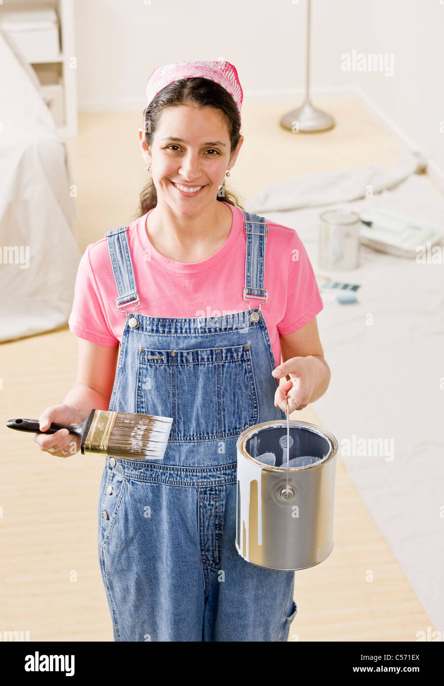 Woman holding paint bucket à la maison Banque D'Images
