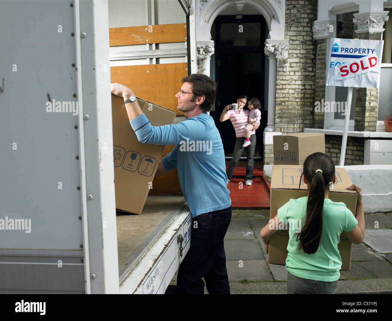 Family unpacking boxes de camion de déménagement Banque D'Images