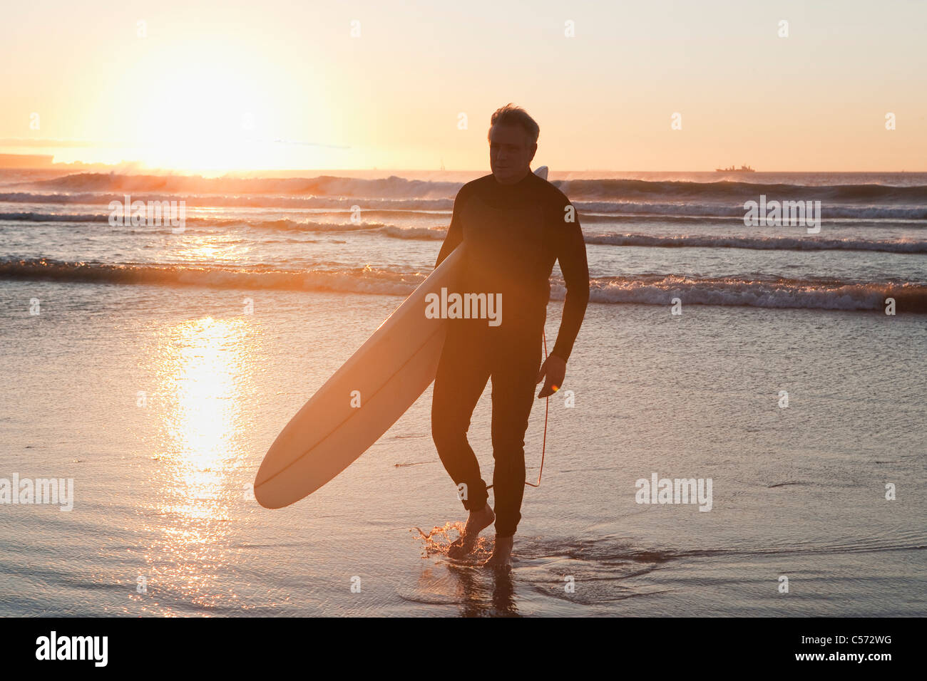 Surfer walking dans l'eau Banque D'Images