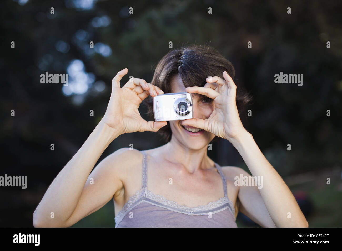 Femme de prendre une photo à l'extérieur Banque D'Images