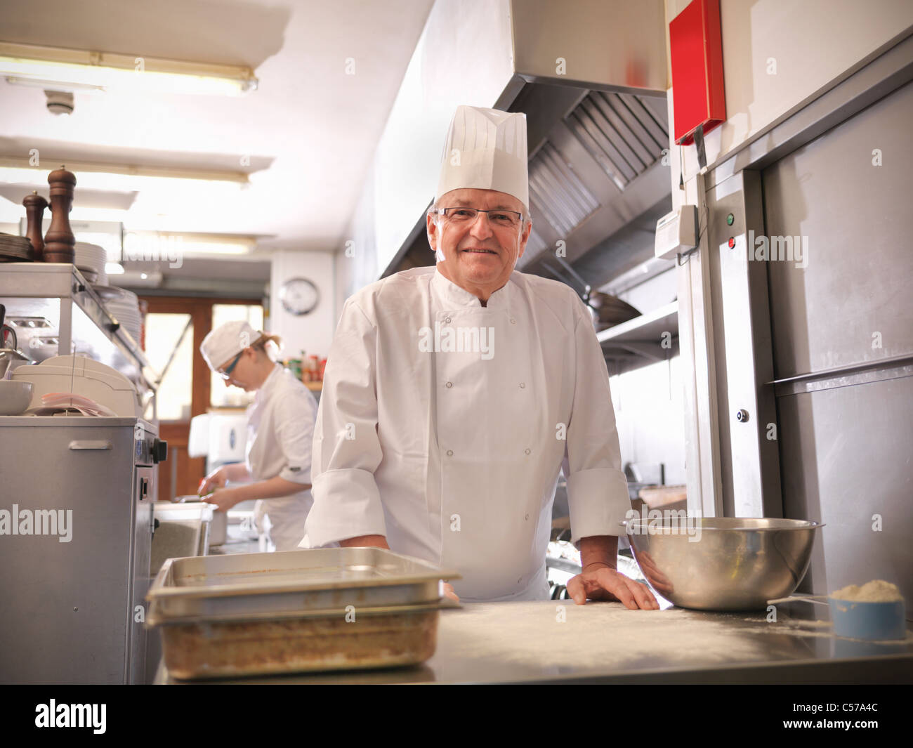 Chef smiling in restaurant kitchen Banque D'Images