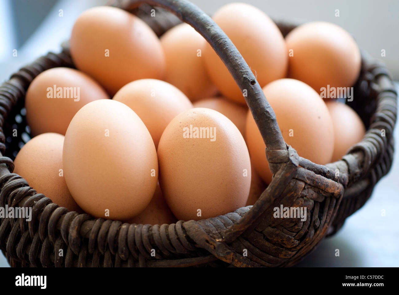 Panier plein d'œufs sur une table en bois Banque D'Images