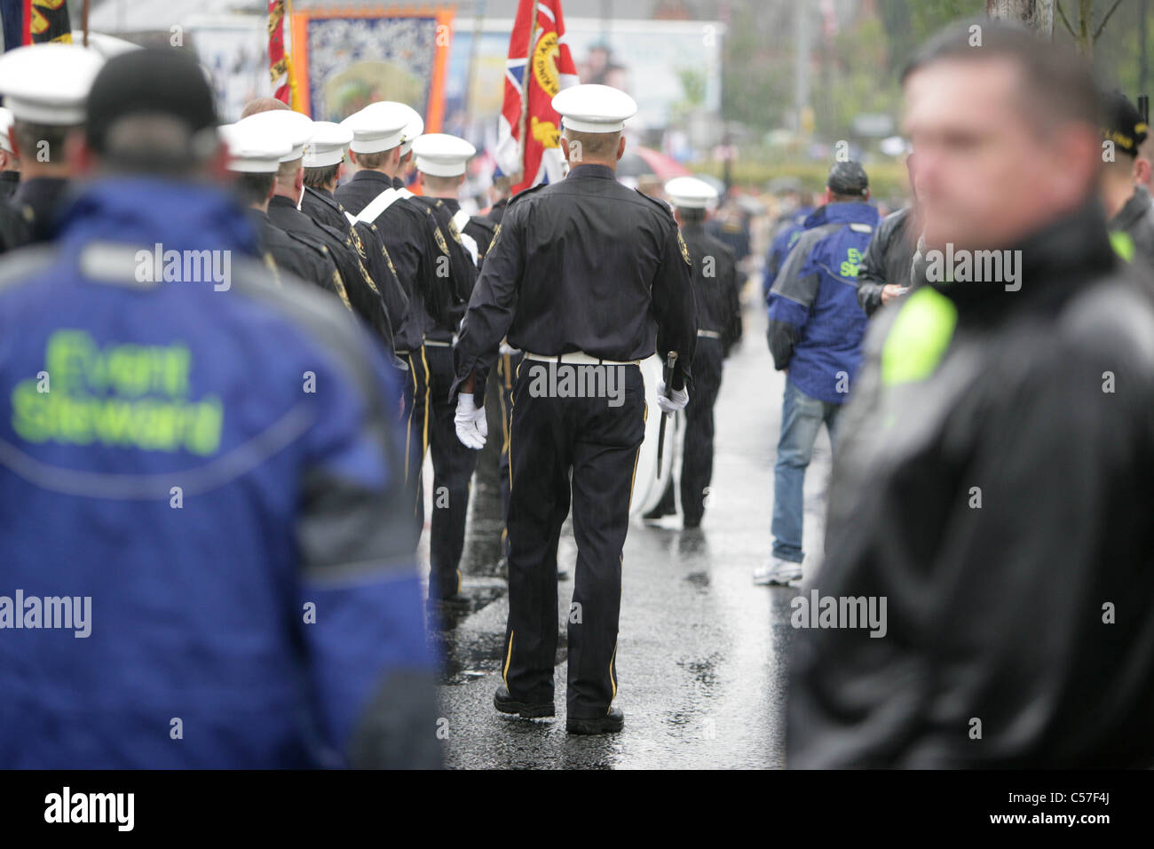 Les Orangistes Protestants loyalistes et musiciens à pied depuis l'Ardoyne nationaliste boutiques sur la route de Belfast Nord à Crumlin Banque D'Images