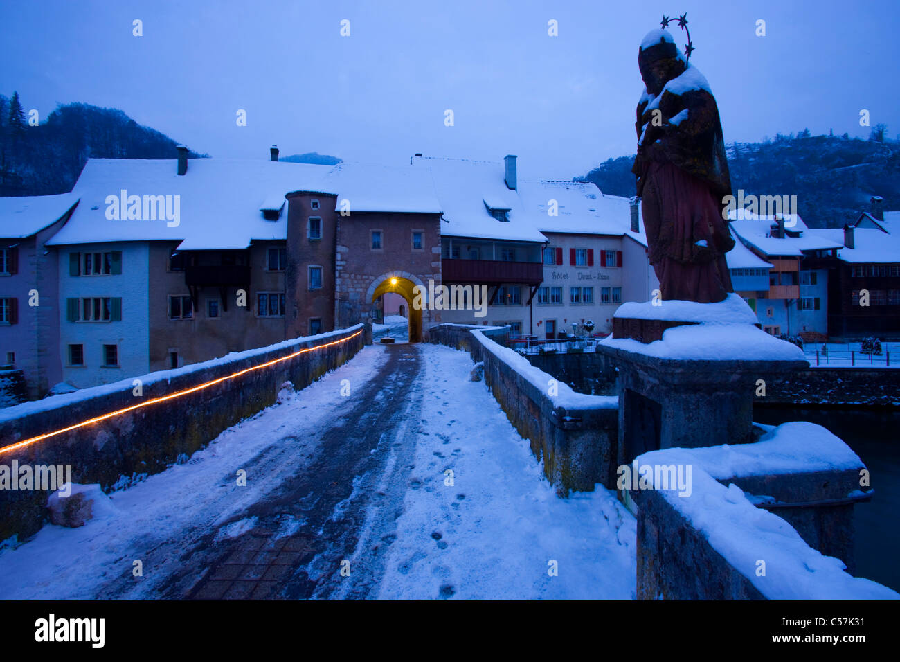 Saint-Ursanne, Suisse, Europe, canton Jura, ville de province, les maisons, maisons, pont, statue, daybreak, éclairage, feux, sno Banque D'Images