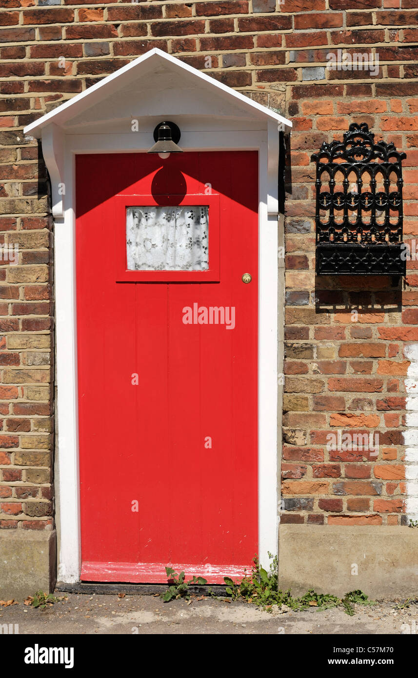 Porte en bois peint rouge à vieille brique cottage à Shoreham. Kent. L'Angleterre Banque D'Images