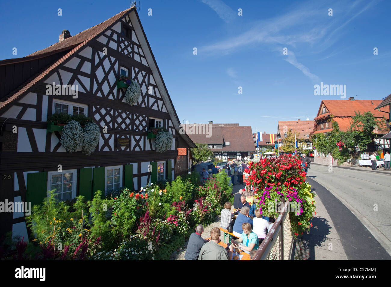 Menschen vor einem Bauernhaus in Sasbachwalden, personnes à la maison à colombage avec décoration florale Banque D'Images