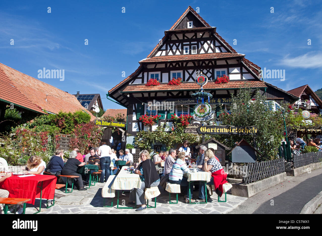 Personnes dans un restaurant avec jardin, maison à colombages, décoration florale, Sasbachwalden, au nord de la forêt noire, forêt noire, Bade-Wurtemberg, Allemagne Banque D'Images