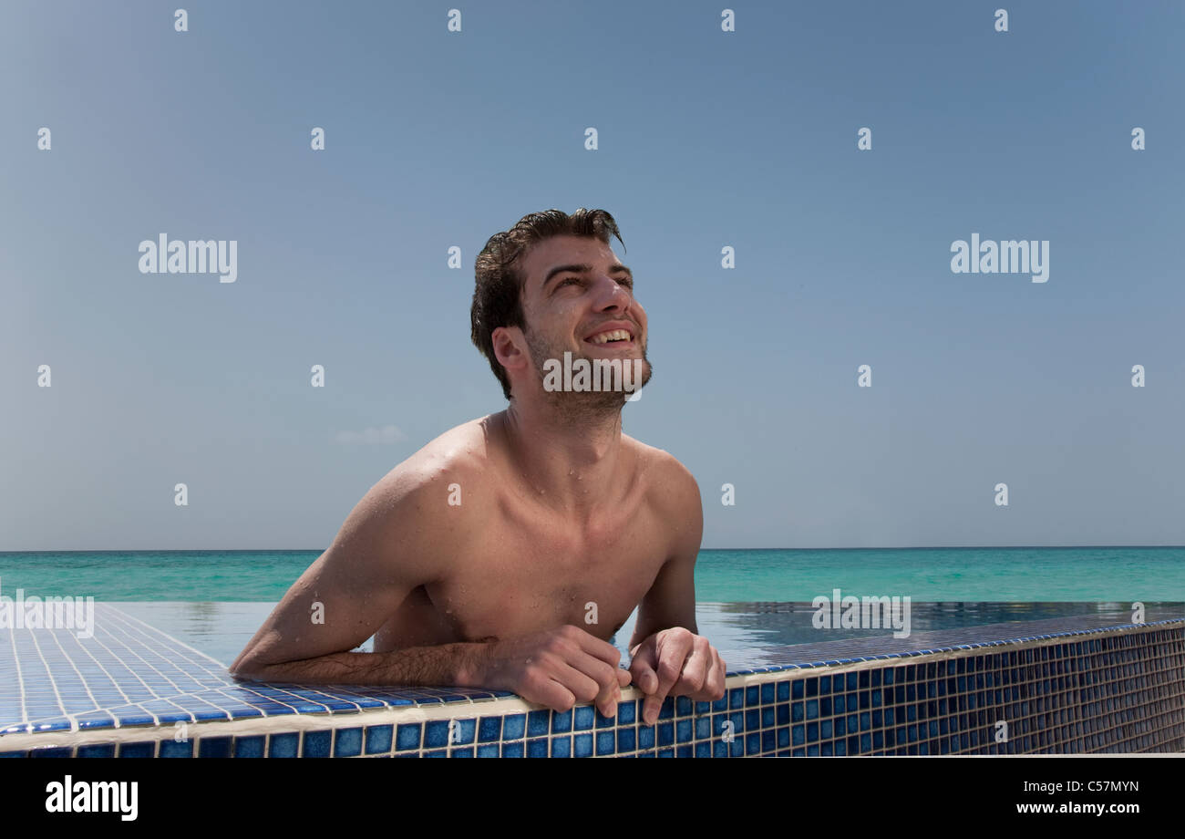 Man relaxing in piscine à débordement Banque D'Images