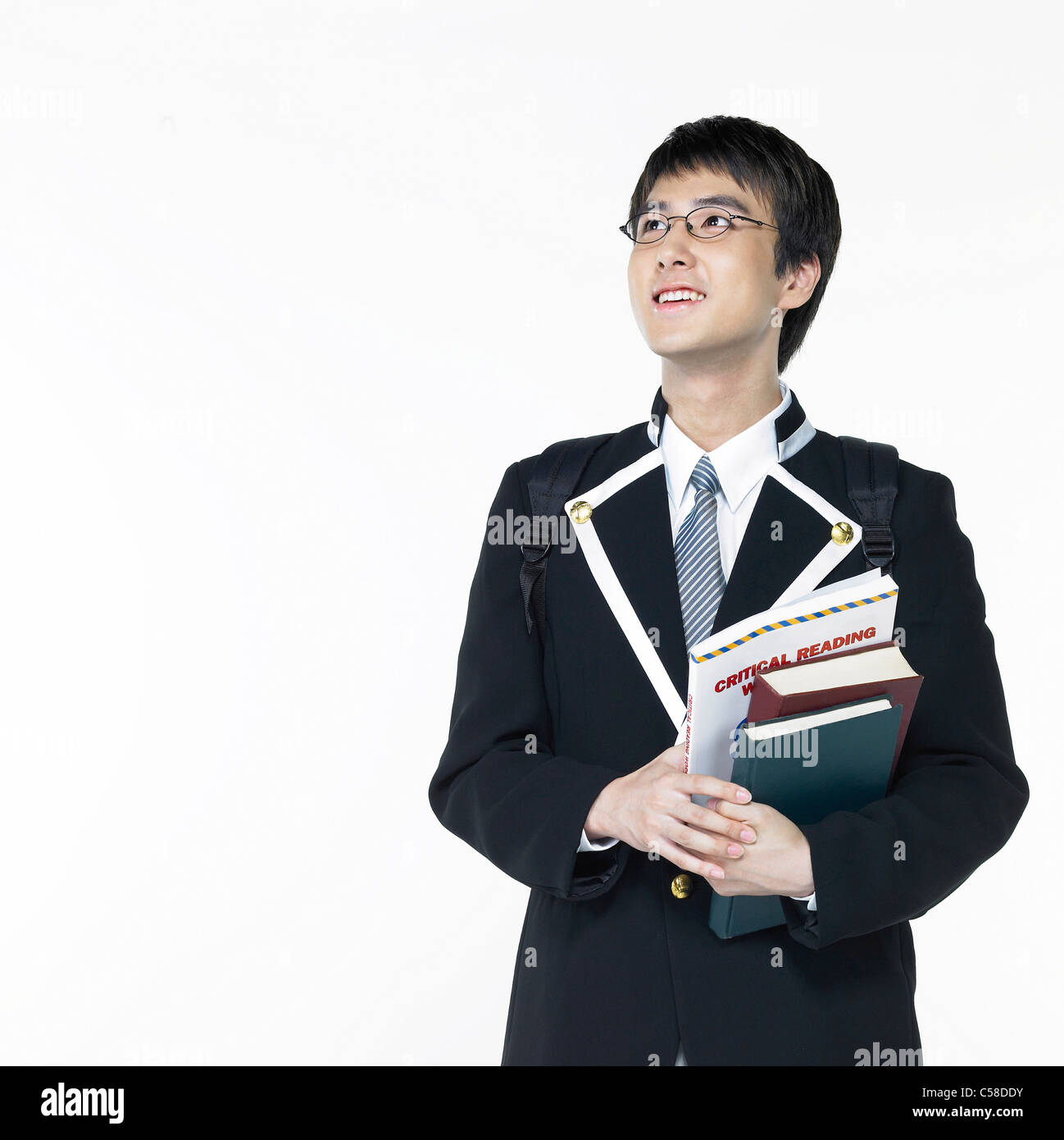Teenage boy standing with books Banque D'Images