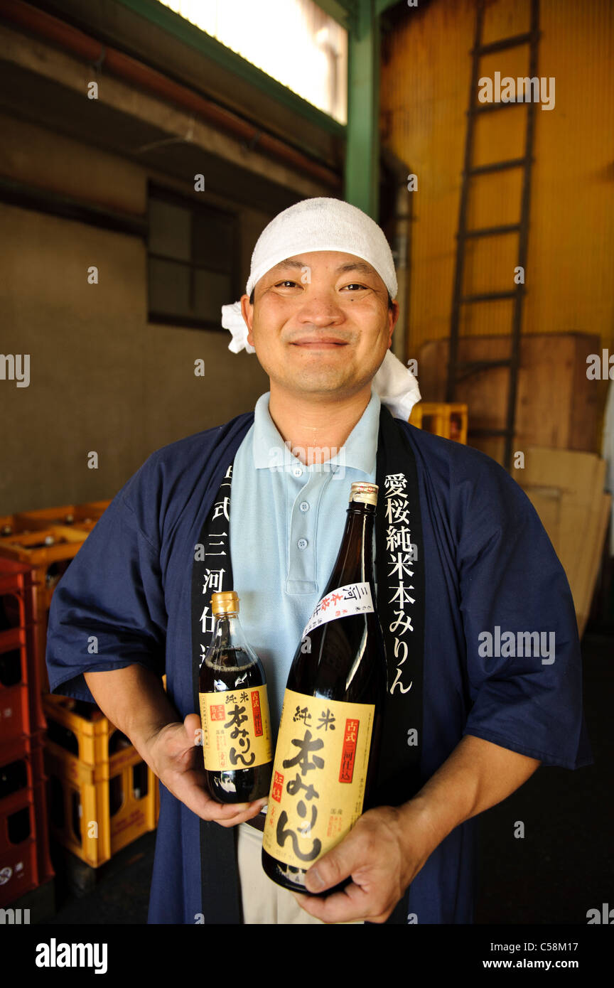 Sugiura Mirin CHEF Yoshinobu Sugiura holding bouteilles de mirin, Hekinan, Aichi pref, Japon, le 28 août 2010. Banque D'Images