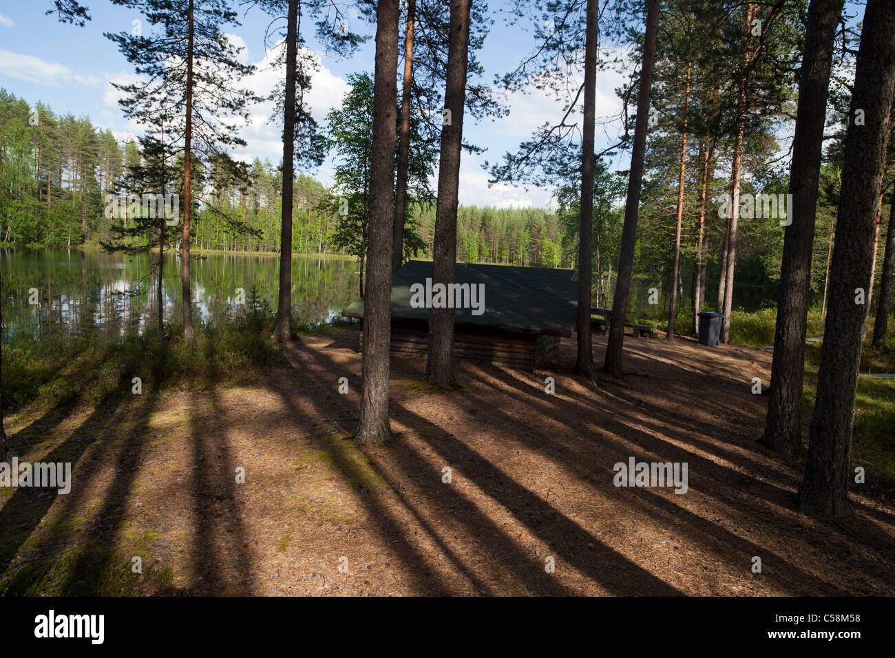 Site de camping par une forêt lac . Petit refuge bivouac en bois offre un abri pour la pluie , Finlande Banque D'Images