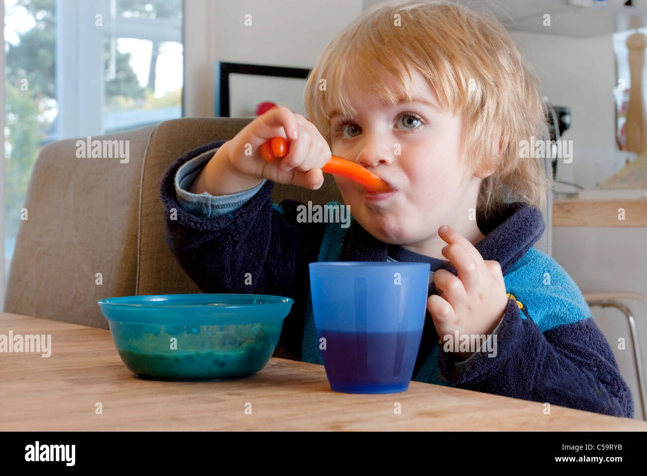 Petit garçon de manger les céréales petit déjeuner dans la cuisine Banque D'Images