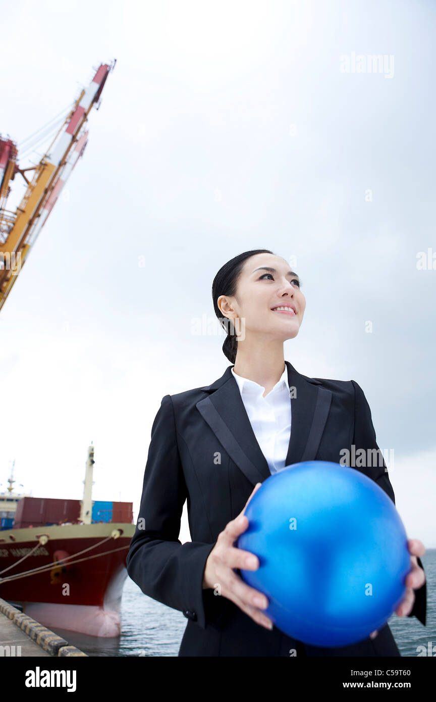 Businesswoman holding blue ball Banque D'Images