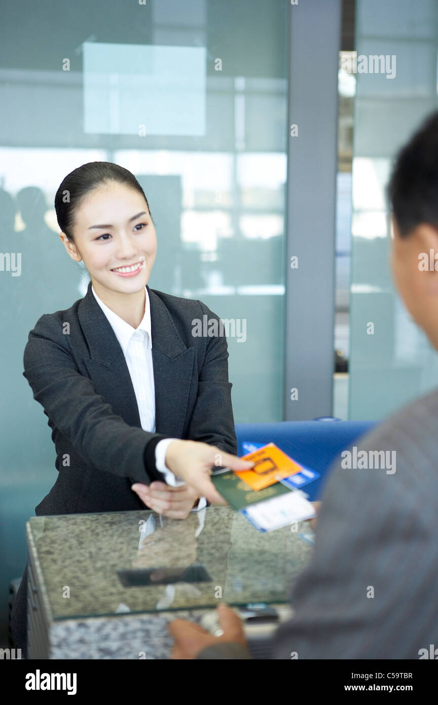 Close-up of businesswoman giving passeport et le billet au comptoir Banque D'Images
