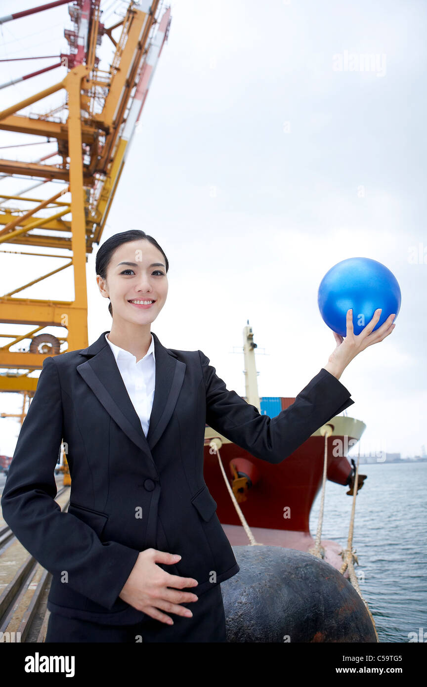 Businesswoman holding blue ball Banque D'Images