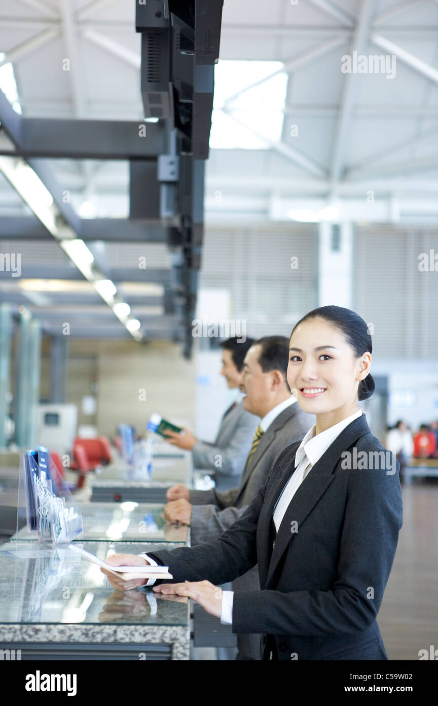 Portrait of businesswoman giving passeport et le billet au comptoir Banque D'Images