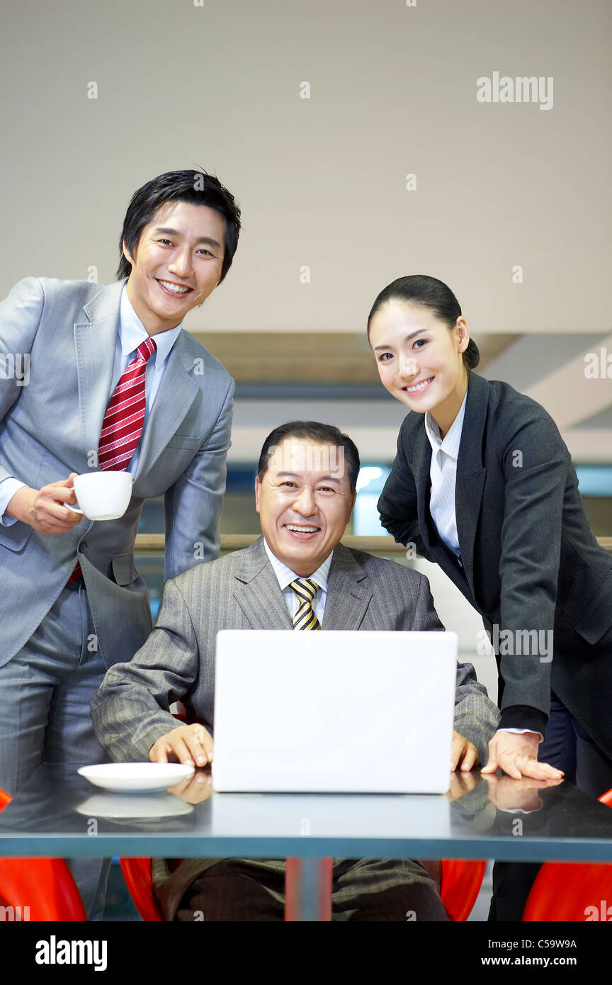 Portrait of business people using laptop at airport lounge Banque D'Images