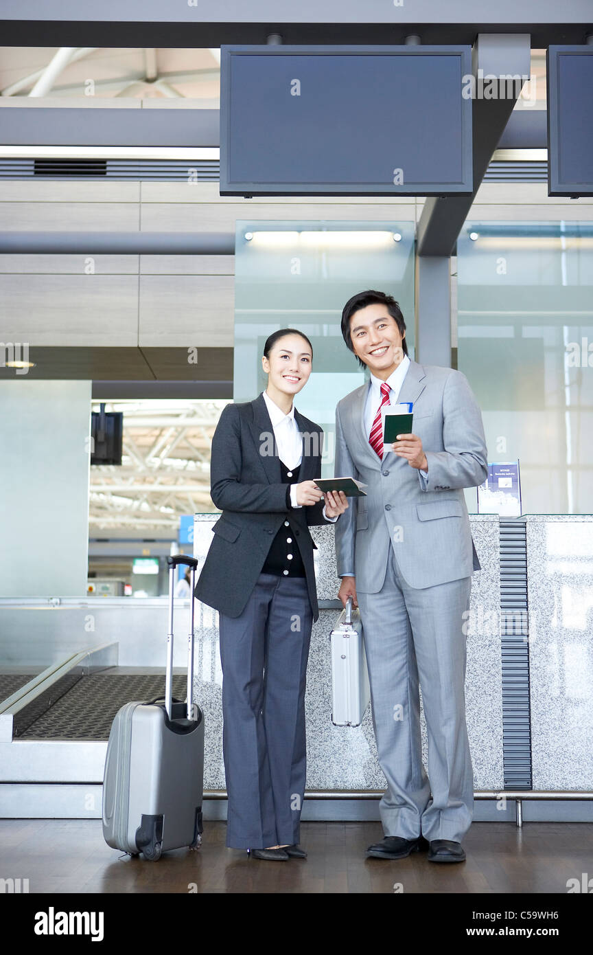 Businessman and businesswoman holding passeport et le billet sur le terminal de l'aéroport Banque D'Images
