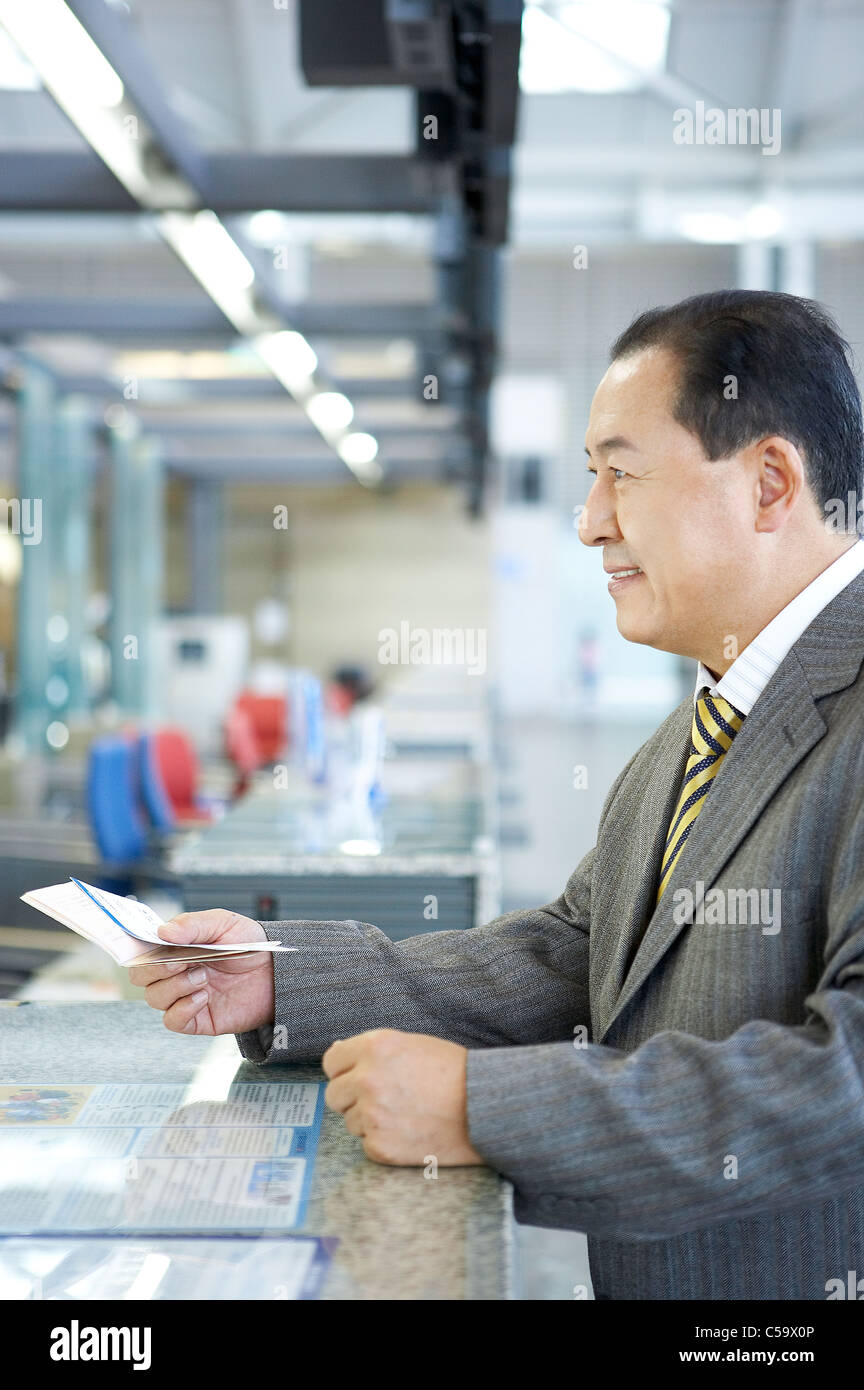 Side view of businessman holding passeport et le billet au comptoir Banque D'Images