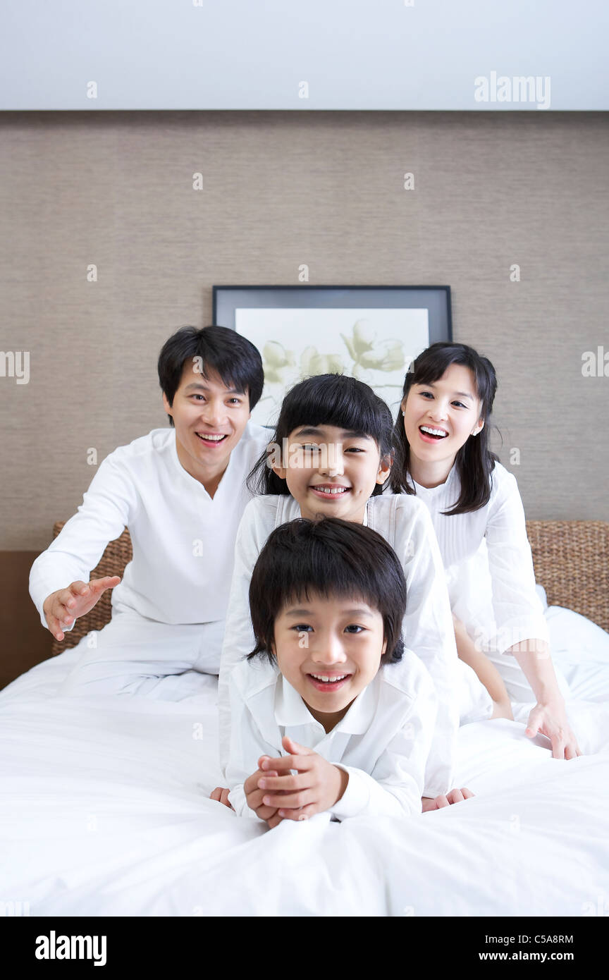 Family enjoying on bed Banque D'Images