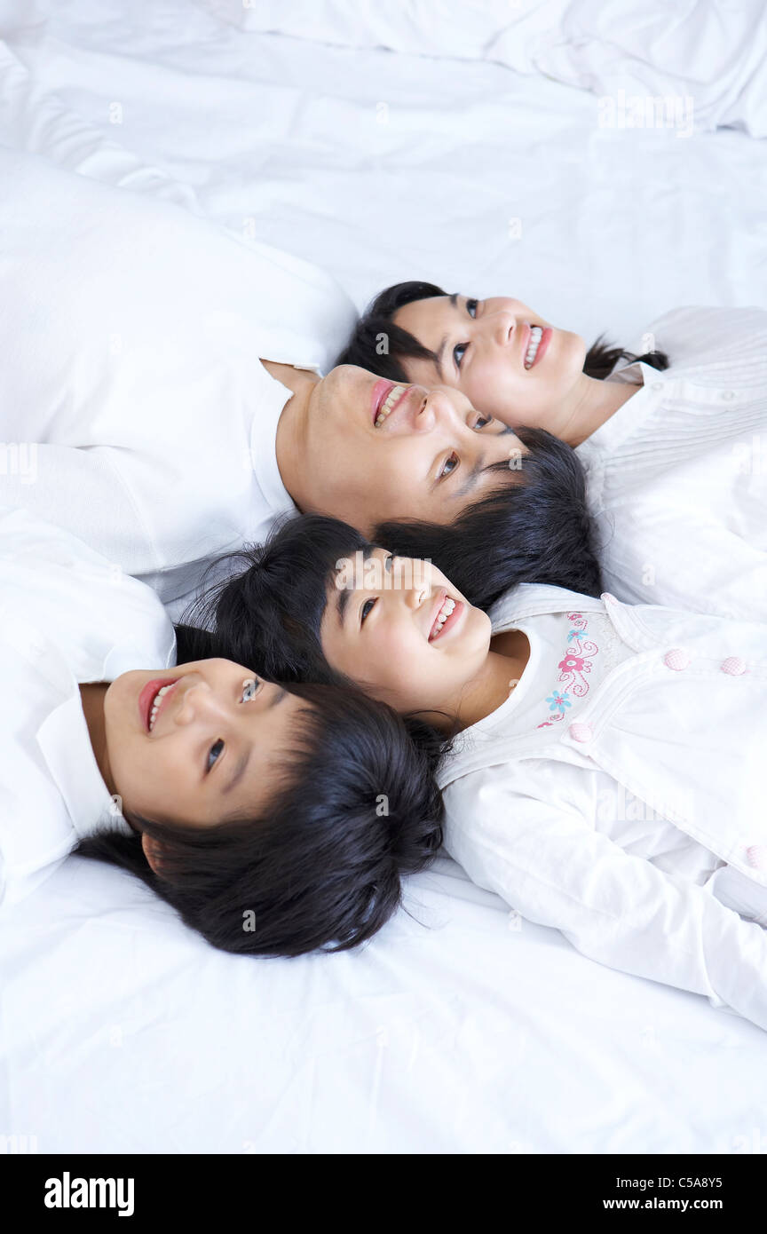 Portrait of Family enjoying on bed Banque D'Images