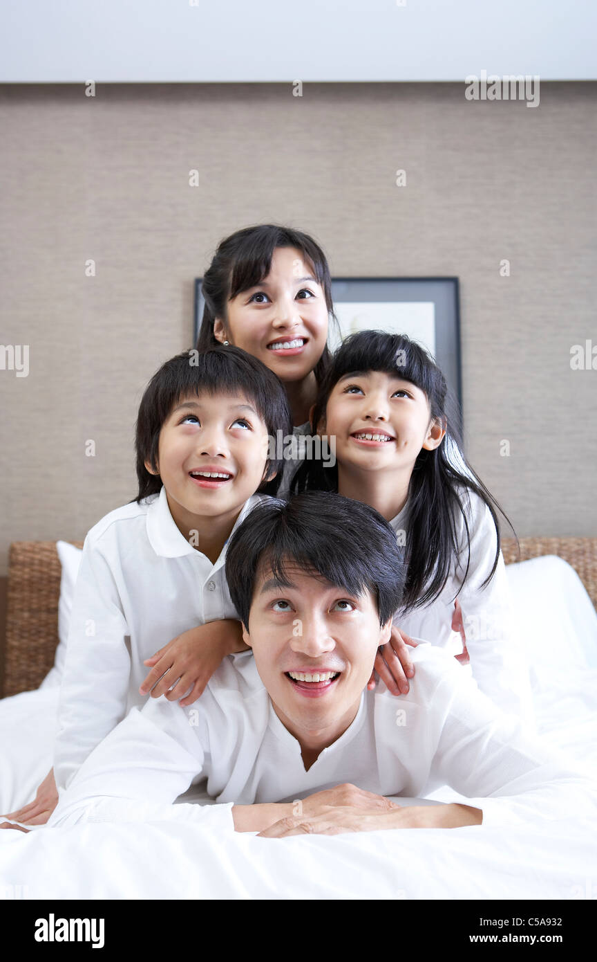 Family enjoying on bed Banque D'Images