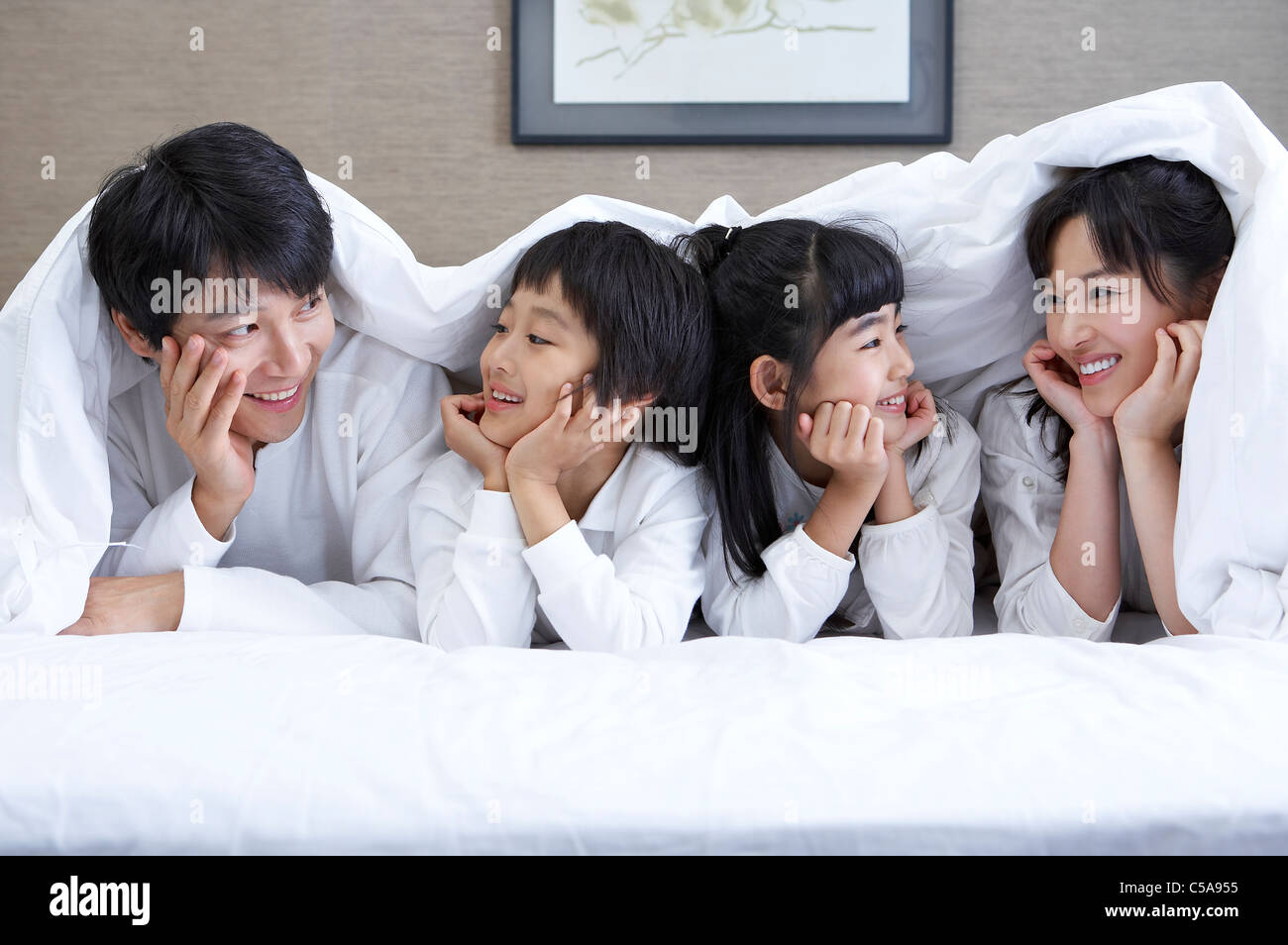 Close-up of family smiling on a bed Banque D'Images