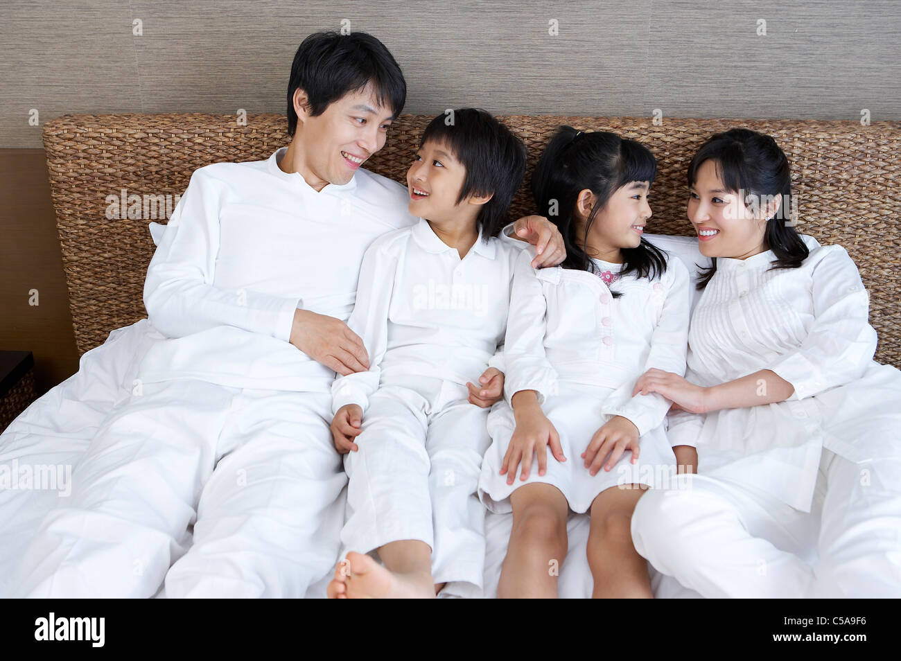 Portrait of family smiling on a bed Banque D'Images