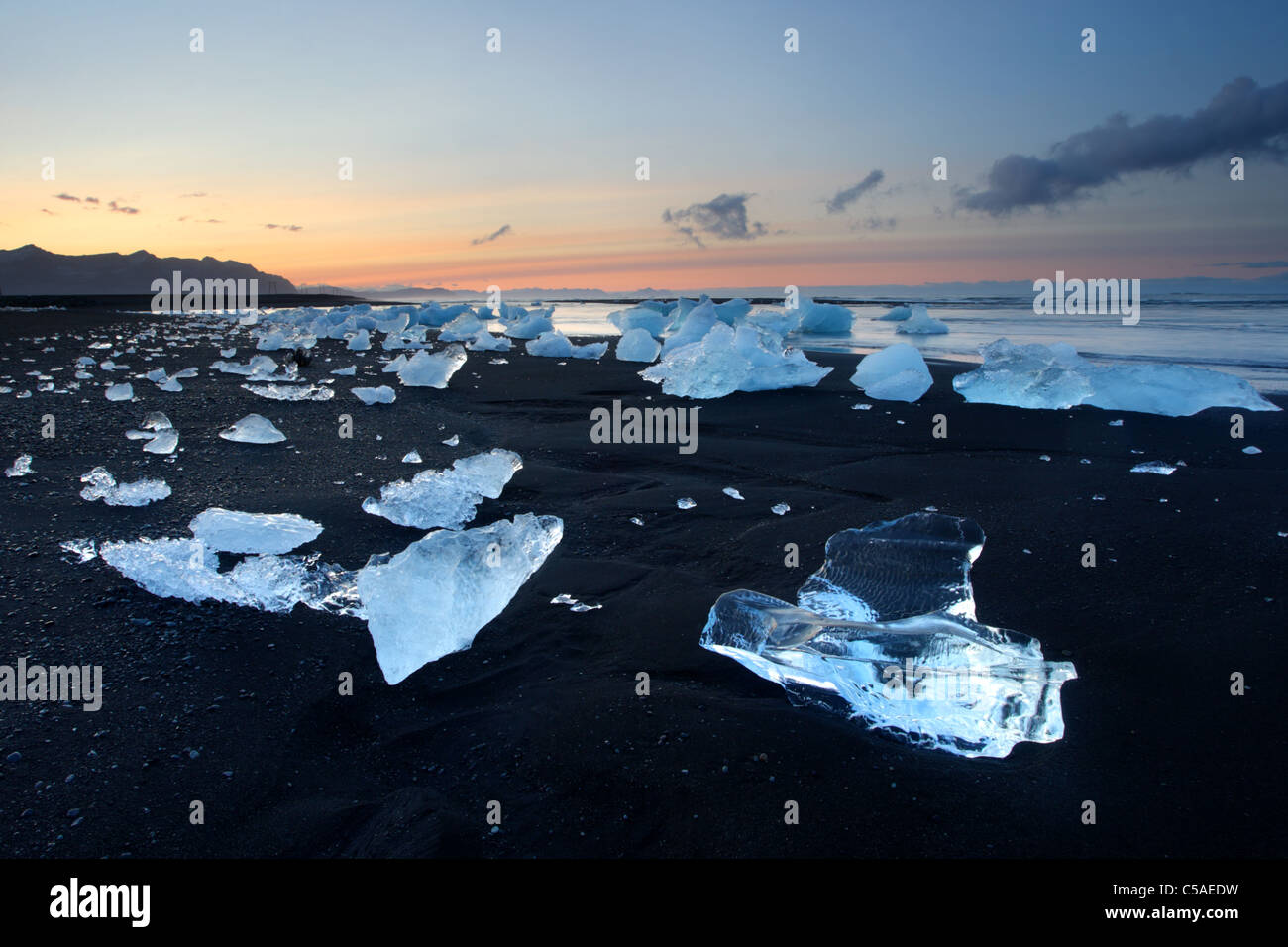 De gros morceaux de glace de glacier sur la plage de sable noir, l'Islande, Jökulsárlón. Banque D'Images