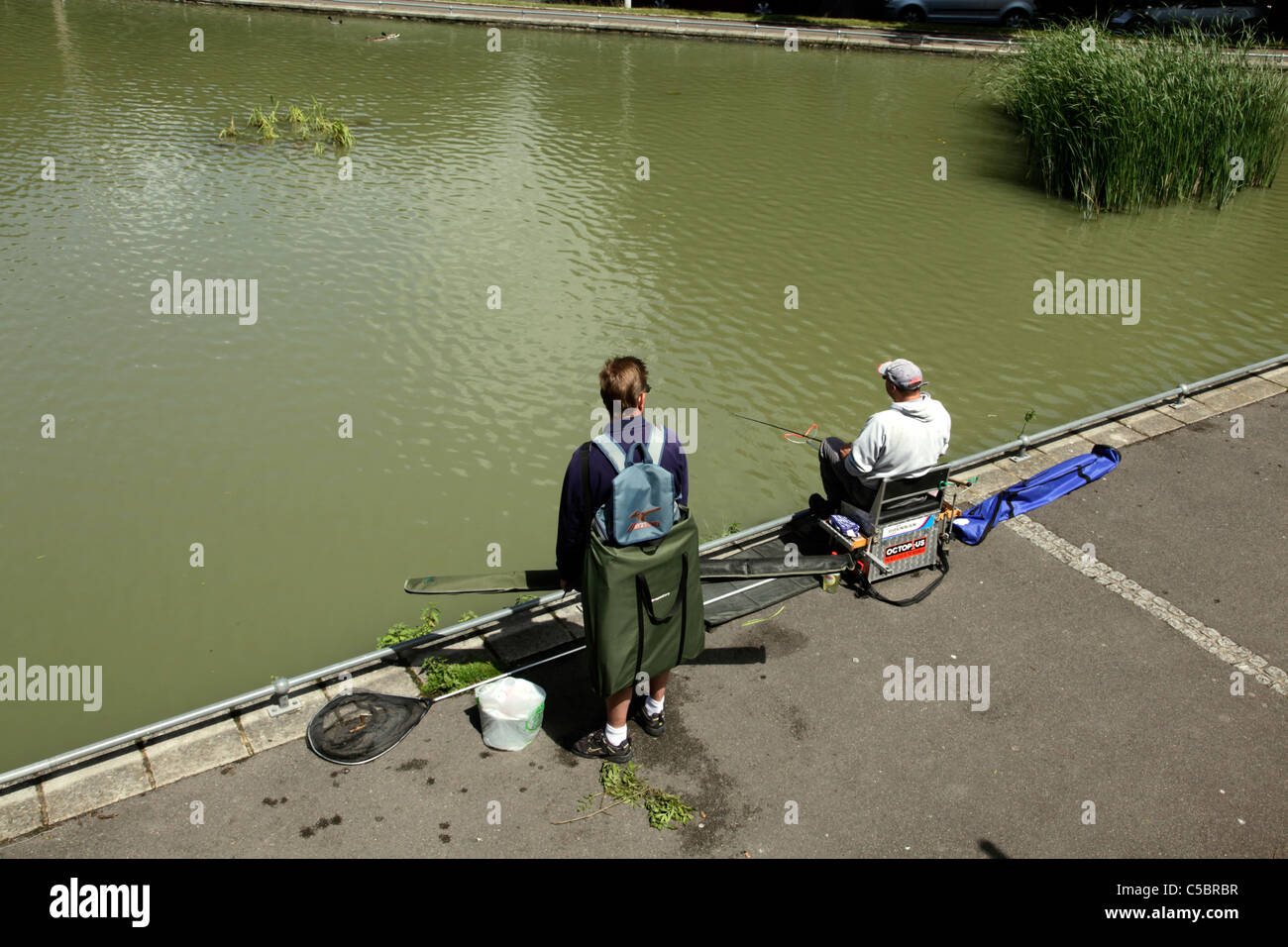 Deux pêcheurs à l'étang de pêche à proximité de Folkestone Park Radnor Banque D'Images