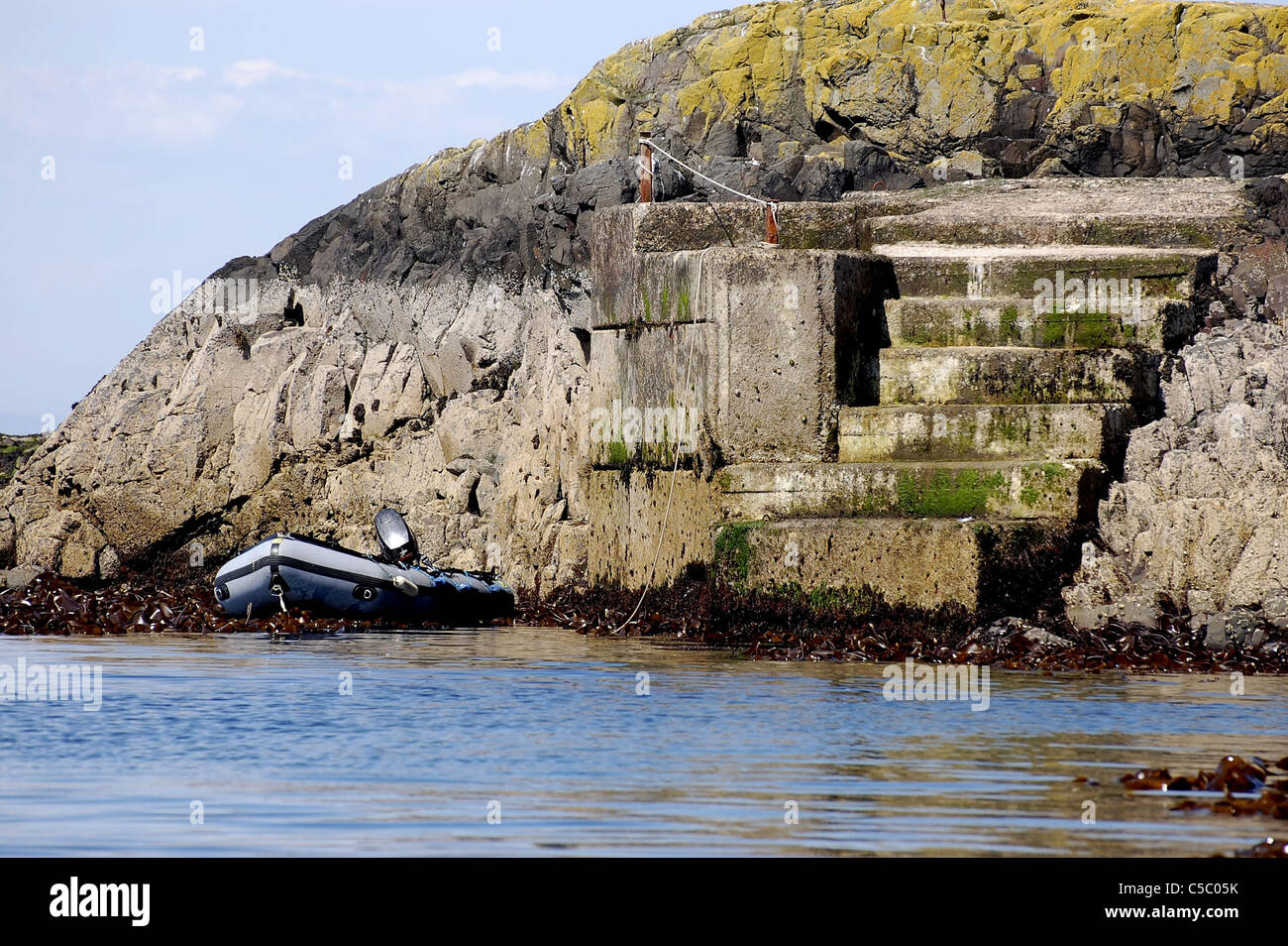 Sur le ponton d'îles Farne avec canot et moteur hors-bord attaché au pied de celui-ci. Banque D'Images