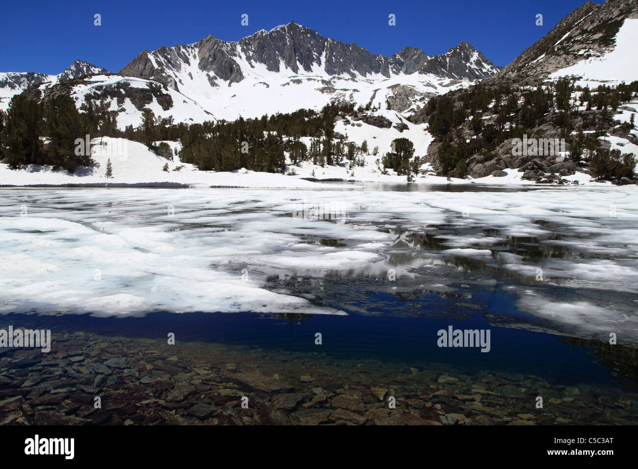 La glace et la neige en haute montagne avec le Mont du Lac Long Goode en arrière-plan dans la Sierra Nevada de Californie Banque D'Images